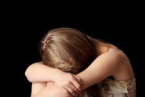 Young woman depression isolated on black background
